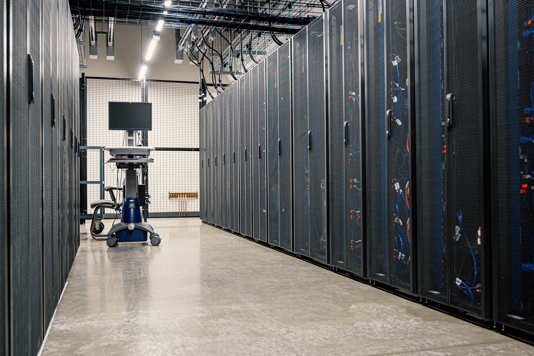 A data-centre aisle of locked cabinets — the space colocation customers rent.